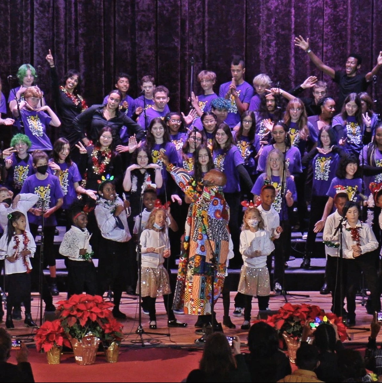 Artistic Director enthusiastically gestures in front of large youth ensemble