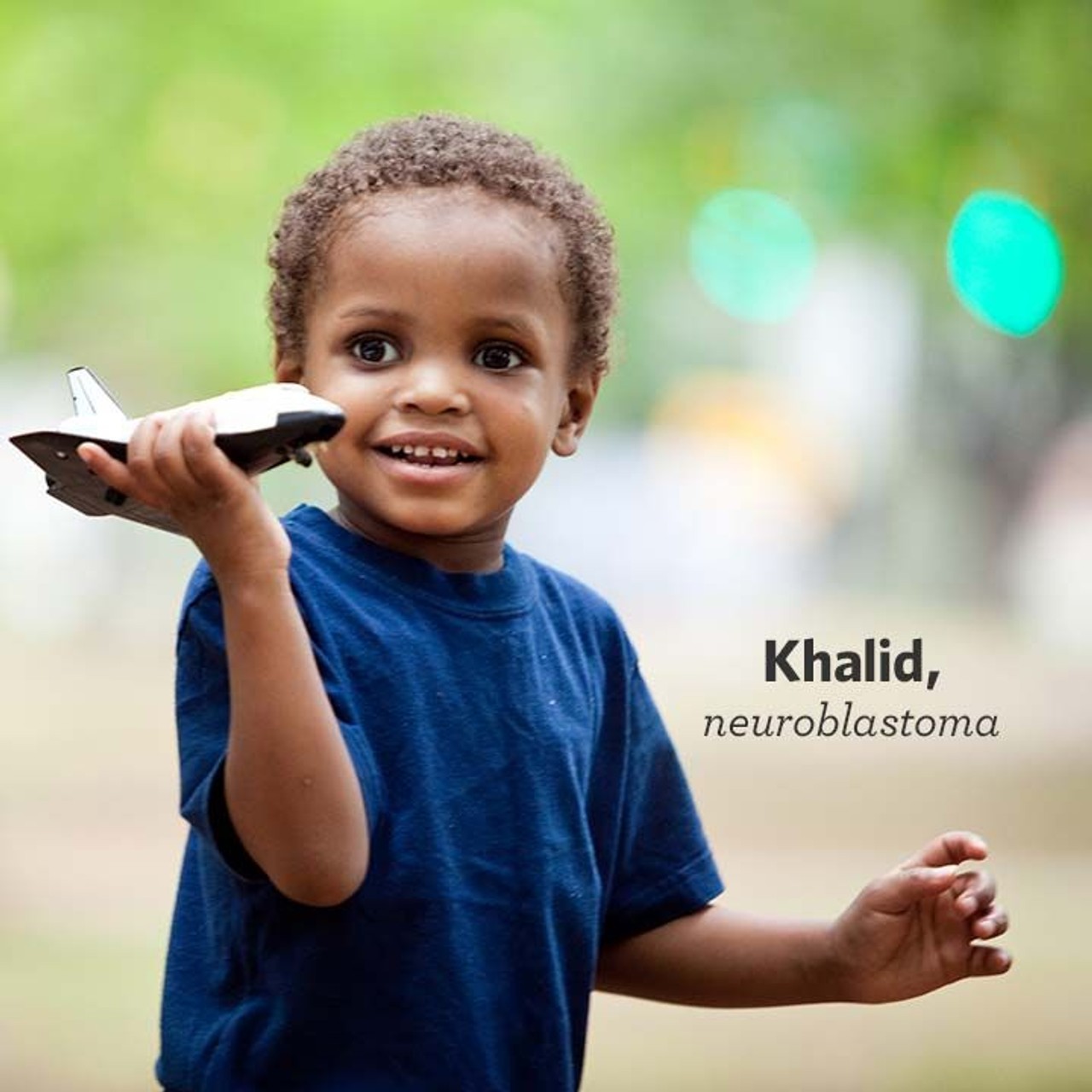 Honored kid Khalid playing with a toy spaceship and smiling