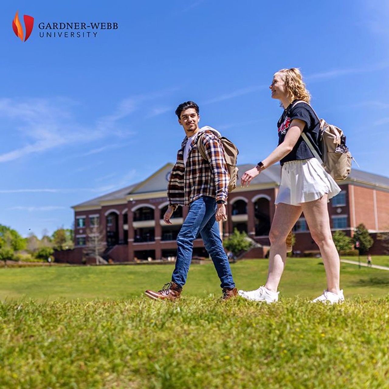 two students walking around lake in front of tucker student center