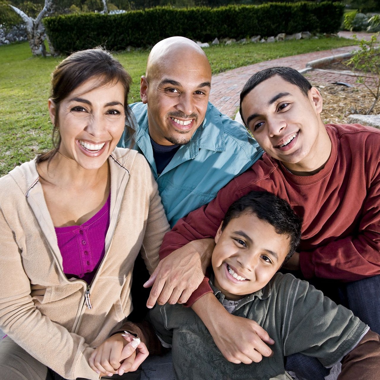Mom, dad and two teenage sons enjoying a day in the yard.